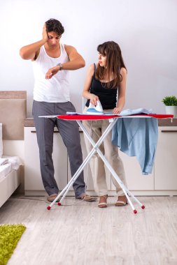 Genç kadın kocası için ütü yapıyor.