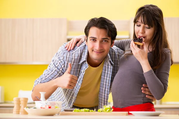 Man and pregnant woman preparing salad in kitchen — Stock Photo, Image