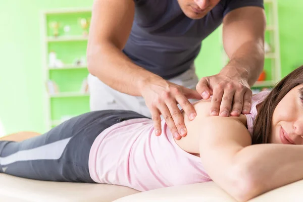 Joven médico quiropráctico masajeando paciente — Foto de Stock