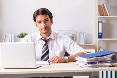 Genç yakışıklı işadamı ofiste çalışıyor.
