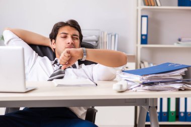 Genç yakışıklı işadamı ofiste çalışıyor.