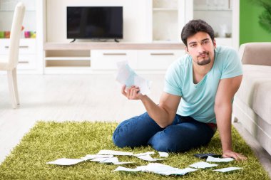 Genç adam kişisel finans ve faturalarla boğuşuyor.