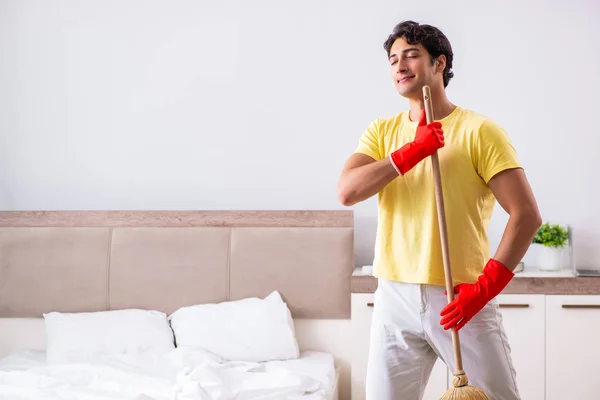 Joven hombre guapo limpieza en el dormitorio —  Fotos de Stock