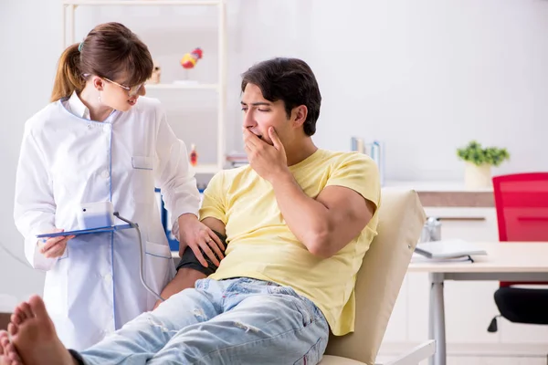 Junger Arzt überprüft Blutdruck seiner Patienten — Stockfoto