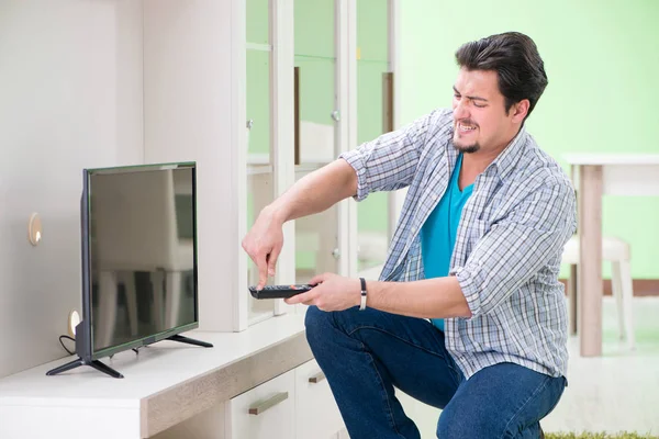 Young man husband repairing tv at home