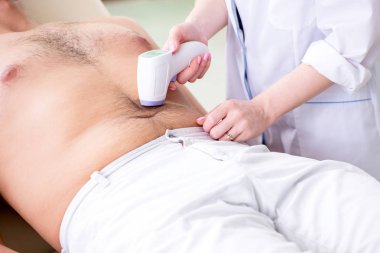 Genç adam epilasyon için doktoru ziyaret ediyor.