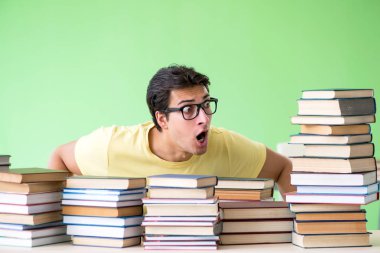 Sınavdan önce okumak için çok fazla kitabı olan öğrenci