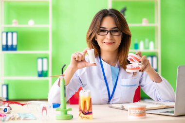 Diş implantı üzerinde çalışan kadın dişçi.