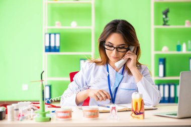 Diş implantı üzerinde çalışan kadın dişçi.