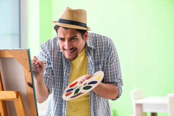 Joven artista masculino trabajando en una nueva pintura en su estudio — Foto de Stock