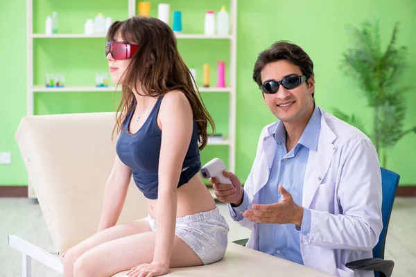 Young woman visiting doctor dermatologist