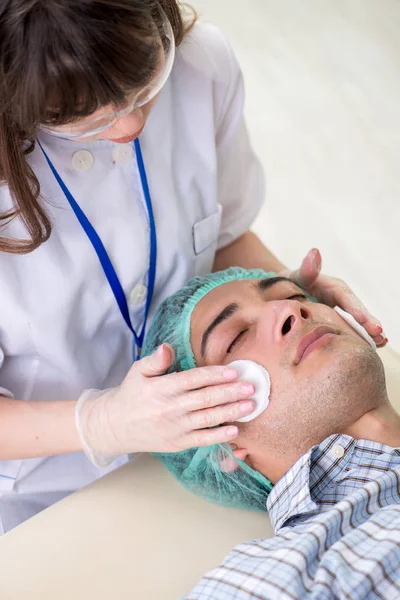 Giovane uomo in visita medico cosmetologo femminile — Foto Stock