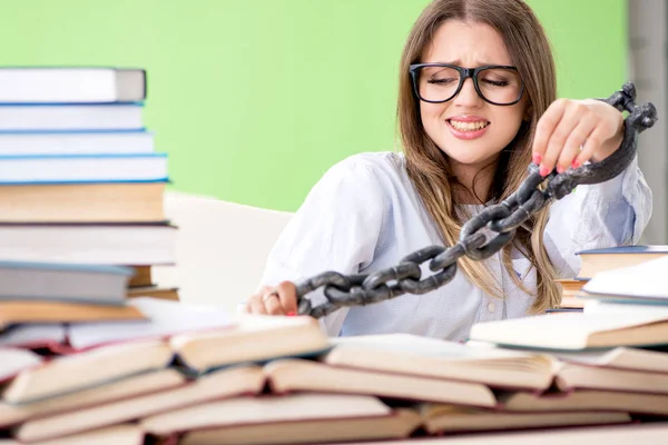 Joven estudiante encadenada al escritorio y preparándose para los exámenes —  Fotos de Stock