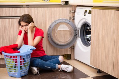 Evde çamaşır yıkayan bir kadın.