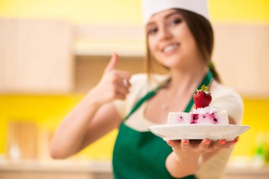 Genç aşçı mutfakta kek pişiriyor.