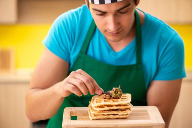 Adam evde pasta hazırlıyor.