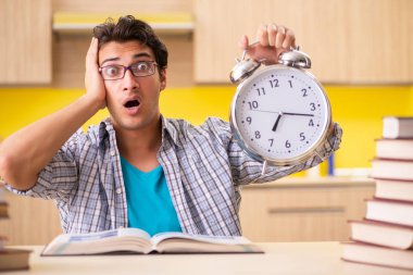 Sınava hazırlanan öğrenci mutfakta oturuyor. 