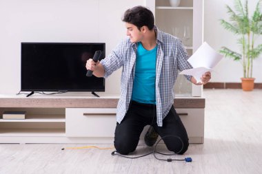 Bozuk televizyonu tamir etmeye çalışan adam