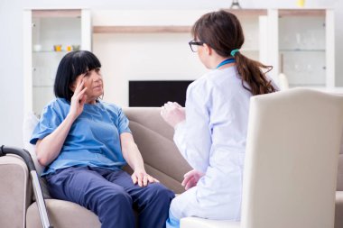 Genç doktor yaşlı kadını muayene etmek için ziyaret ediyor.