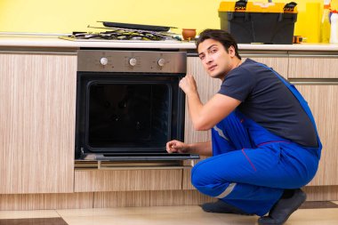 Genç müteahhit mutfak mobilyalarını monte ediyor.