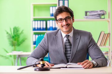 Genç ve yakışıklı avukat ofiste çalışıyor. 