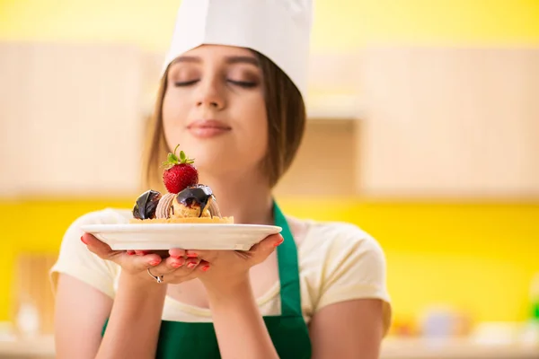 Young cook cooking cakes in the kitchen