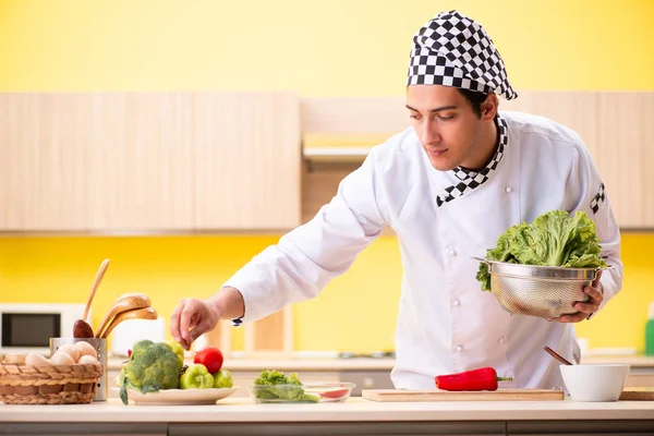 Joven cocinero profesional preparando ensalada en casa — Foto de Stock