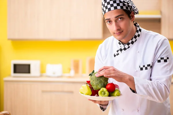 Joven cocinero profesional preparando ensalada en casa — Foto de Stock