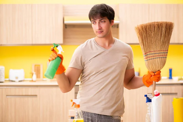Одинокий мужчина убирает кухню дома — стоковое фото