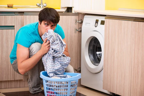 Joven marido hombre haciendo la colada en casa — Foto de Stock