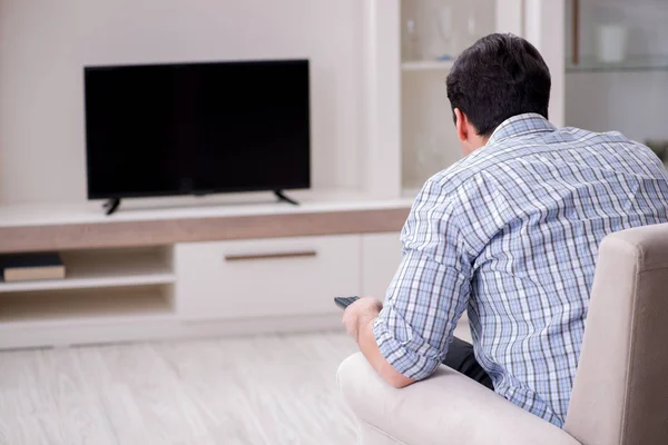 Hombre joven viendo la televisión en casa — Foto de Stock