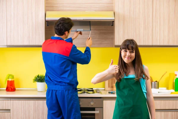 Mulher com empreiteiro na cozinha discutindo reparação — Fotografia de Stock