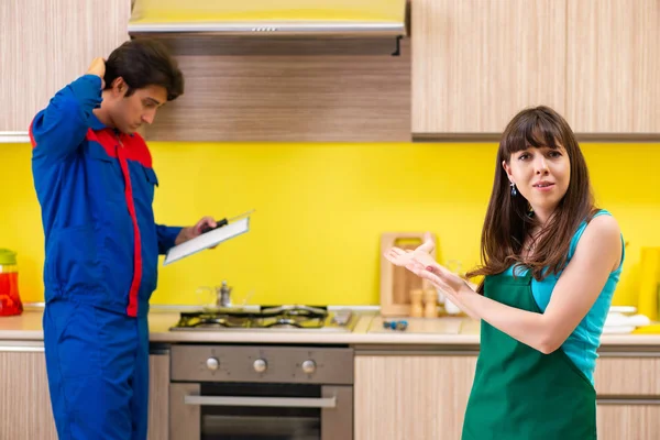 Mutfakta müteahhitle birlikte çalışan bir kadın tamir hakkında konuşuyor. — Stok fotoğraf