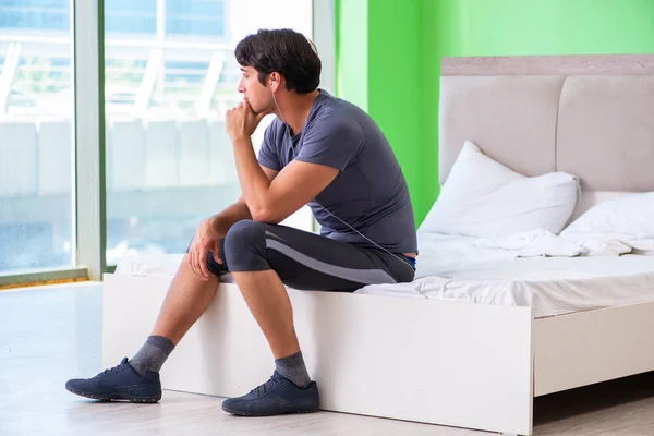 Joven hombre guapo haciendo ejercicios matutinos en la habitación del hotel — Foto de Stock