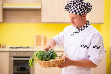 Genç profesyonel aşçı mutfakta salata hazırlıyor.