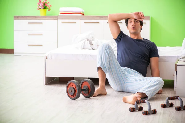 Egy fiatalember pizsamában reggeli gyakorlatokat csinál. — Stock Fotó