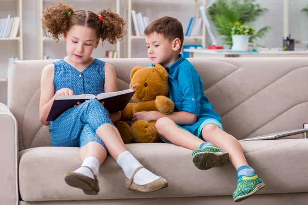 Twee kinderen die thuis boeken lezen — Stockfoto