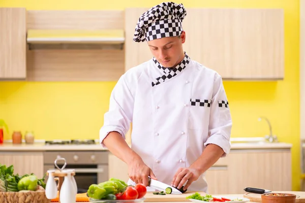 Young professional cook preparing salad at kitchen — Stock Photo, Image