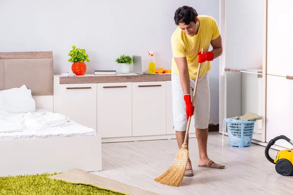 Jovem homem bonito limpeza no quarto — Fotografia de Stock