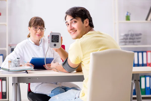 Ung läkare kontrollerar patienter blodtryck — Stockfoto