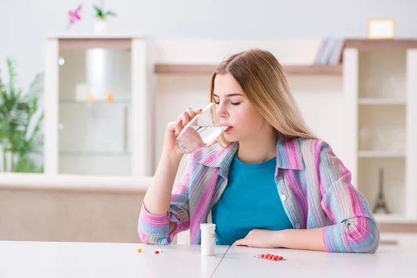 Mujer tomando pastillas para hacer frente al dolor —  Fotos de Stock