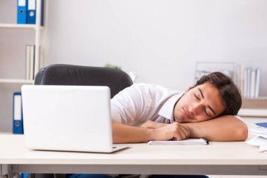 Genç yakışıklı işadamı ofiste çalışıyor.