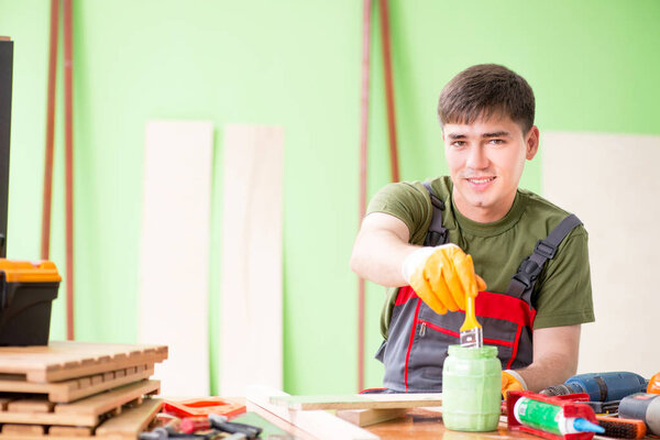 Young man carpenter working in workshop 