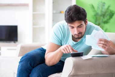 Genç adam kişisel finans ve faturalarla boğuşuyor.