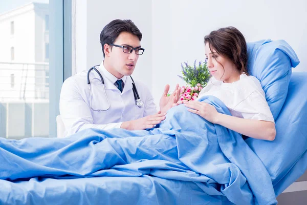 Doktor navštěvující těhotné v nemocničním pokoji — Stock fotografie