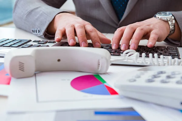 Finance professional working on keyboard with reports — Stock Photo, Image