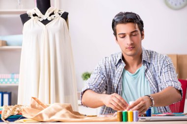 Atölyesinde çalışan yakışıklı bir terzi.