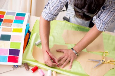 Atölyesinde çalışan yakışıklı bir terzi.