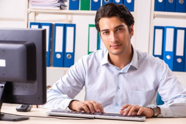 Genç yakışıklı işadamı ofiste çalışıyor.