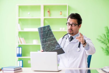 Doktor radyoloji uzmanı hastanede röntgen taramasına bakıyor.